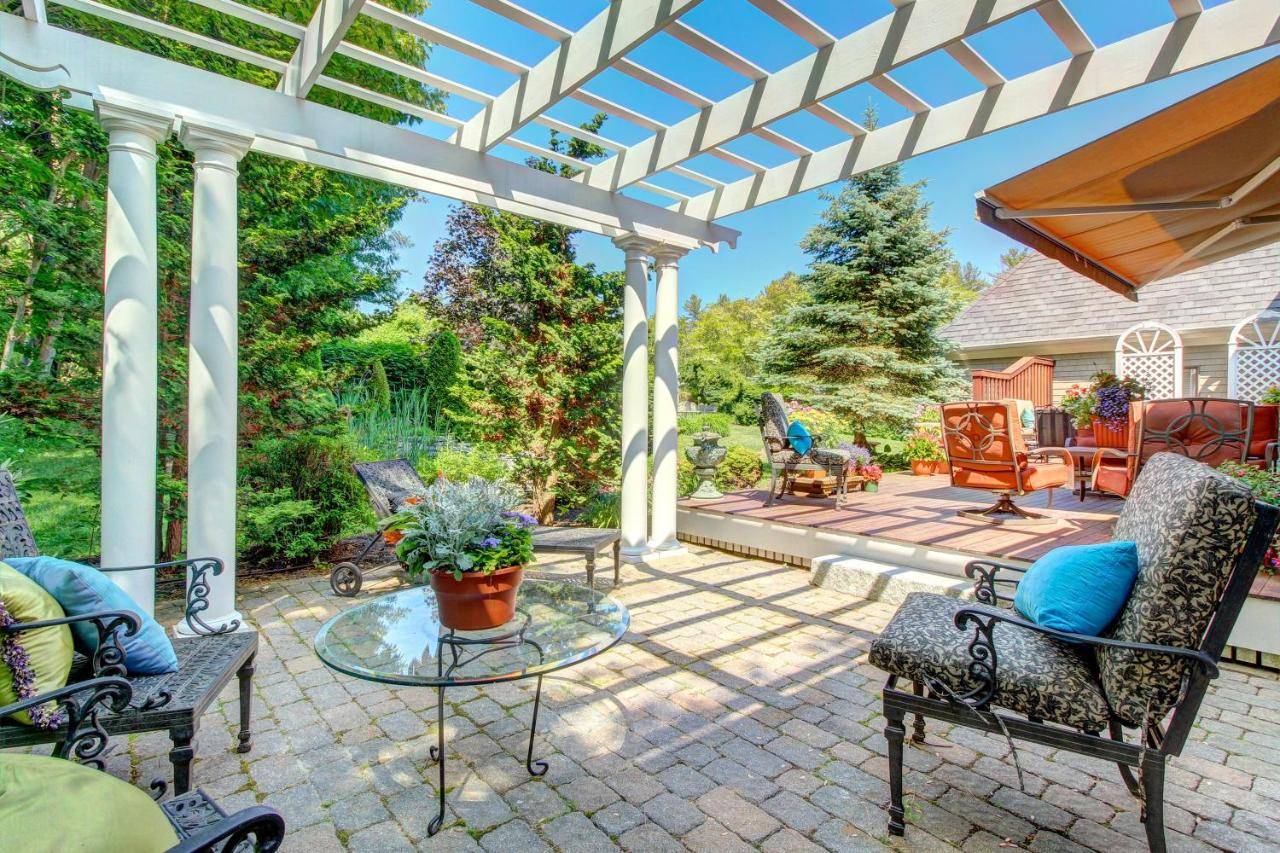 a patio with chairs and a pergola at Grandeur On The Green in Kennebunkport