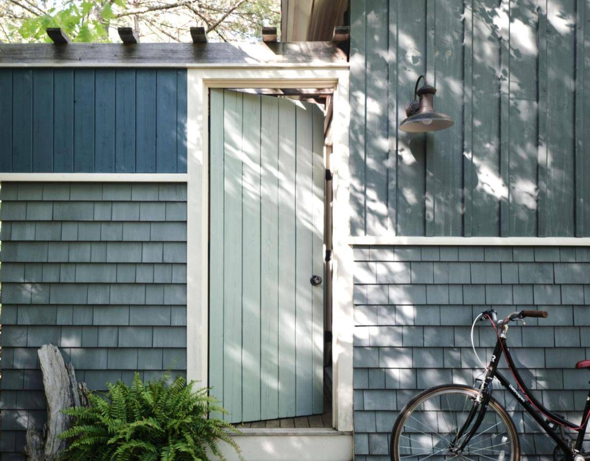 a bike parked outside of a house with a green door at Hidden Pond Resort in Kennebunkport