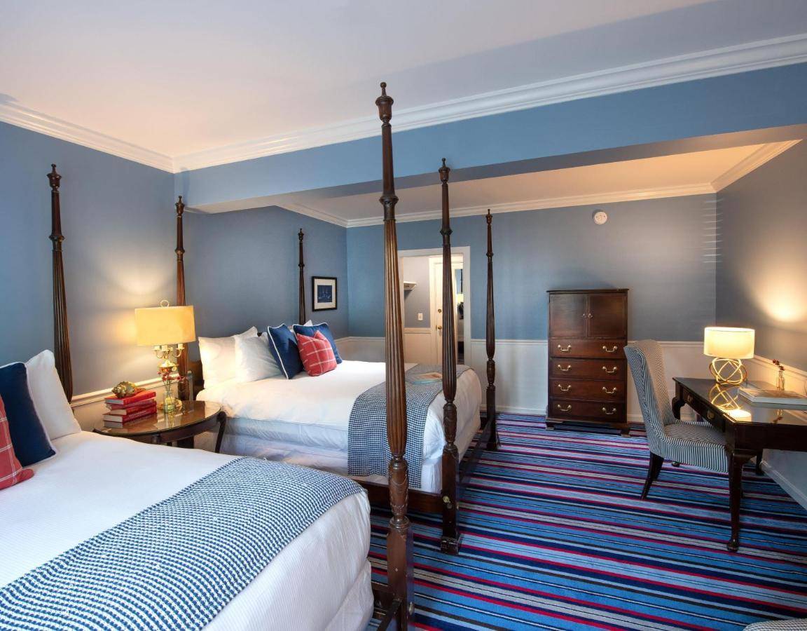 a hotel room with two beds and a desk at Kennebunkport Inn in Kennebunkport