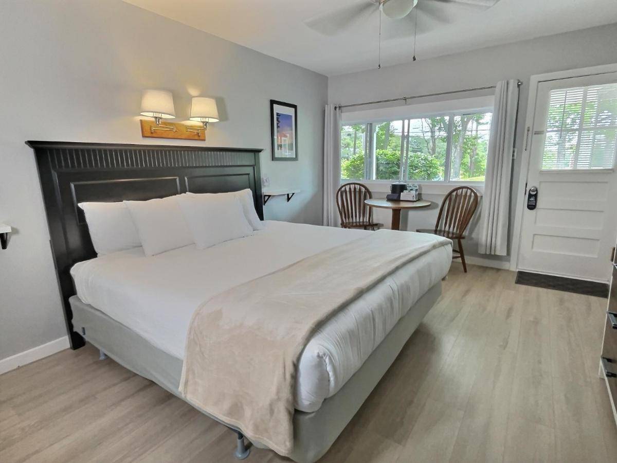 a bedroom with a large bed and a table at Kennebunkport Motor Lodge in Kennebunkport