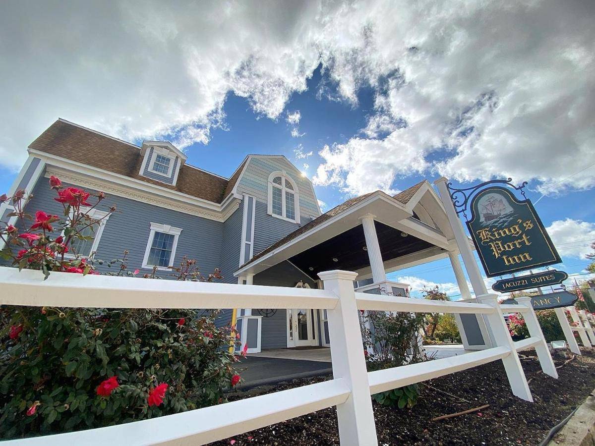 a blue house with a white fence and a sign at King's Port Inn in Kennebunkport