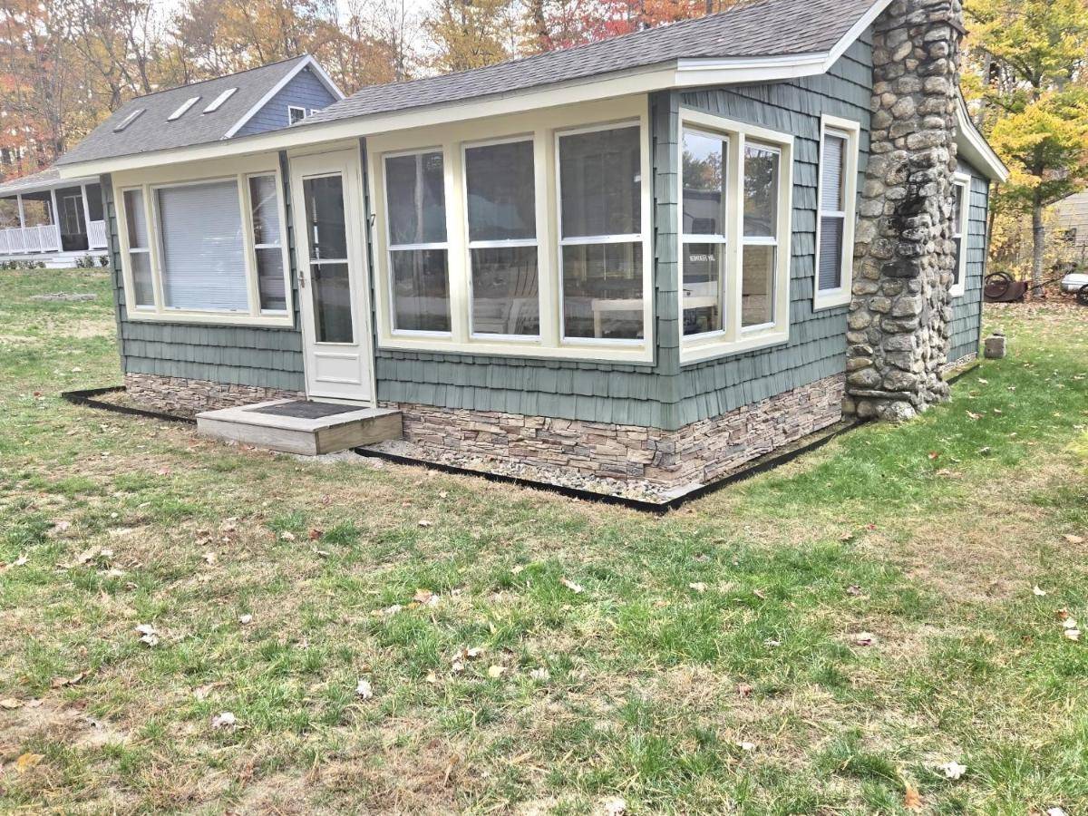 a small green house with a porch and windows at SWALLOW - LIMIT 4 cottage in North Sebago