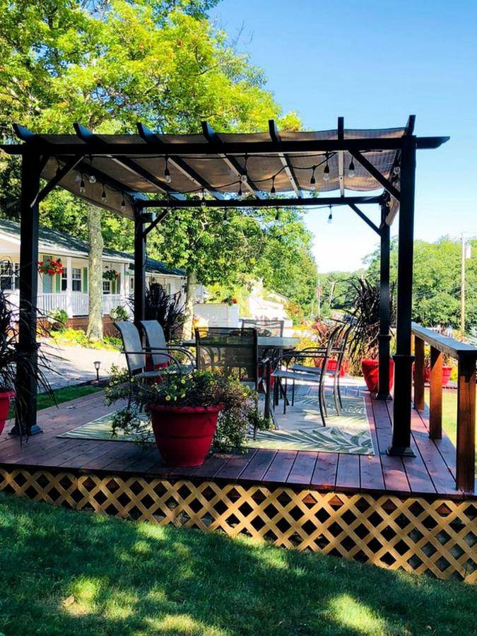 a wooden pergola with chairs and plants on a patio at Romantic Getaway Accommodation Overlooking West Penobscot Bay in Maine in Lincolnville