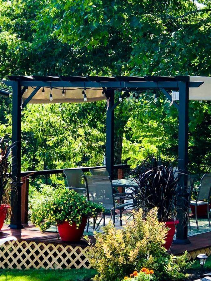 a pergola with chairs and plants on a patio at Stylish Vacation Rental for Couples Overlooking West Penobscot Bay, Maine in Lincolnville