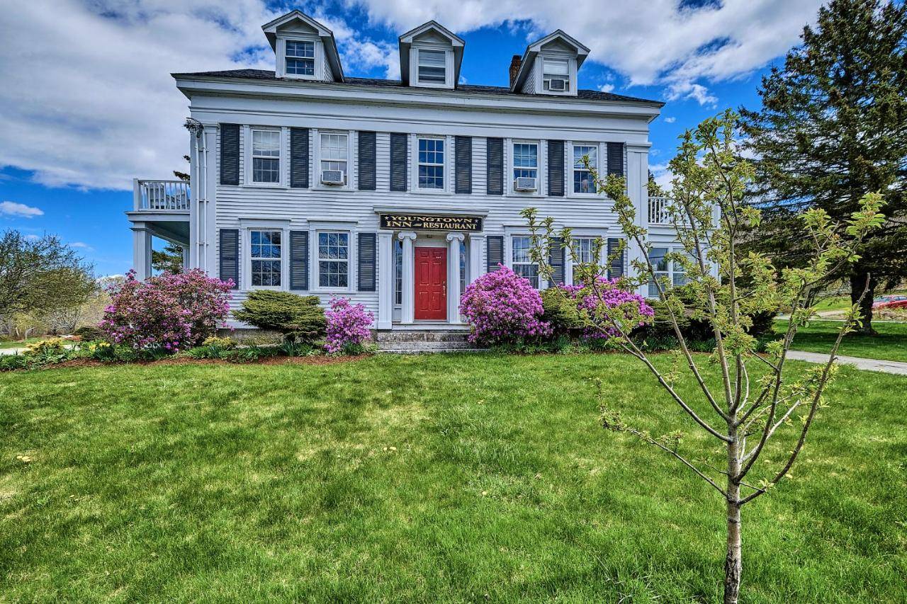 a large white house with a red door at Youngtown Inn in Youngtown
