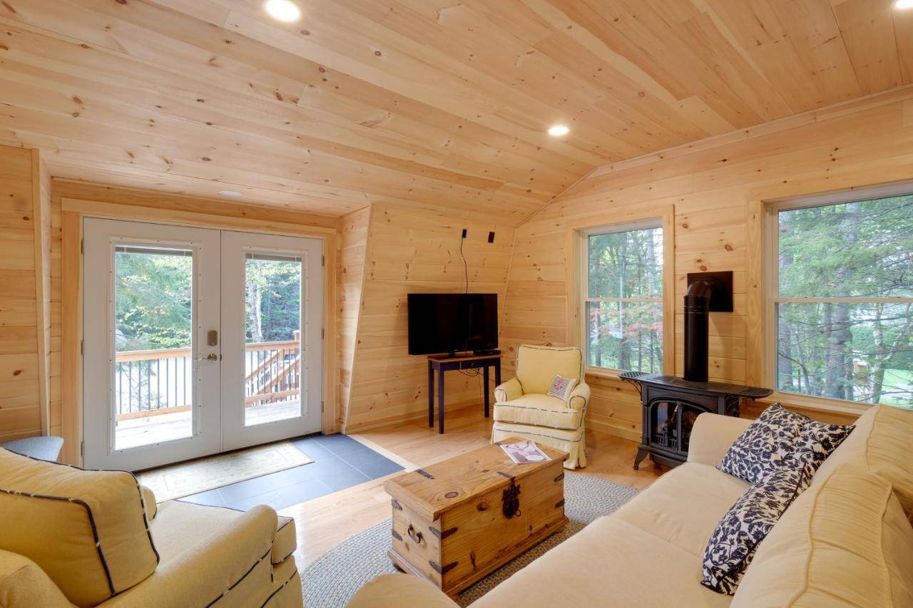a living room with a couch and a tv in a cabin at Cozy Apt with Deck, about 5 Miles to Acadia Natl Park! in Northeast Harbor