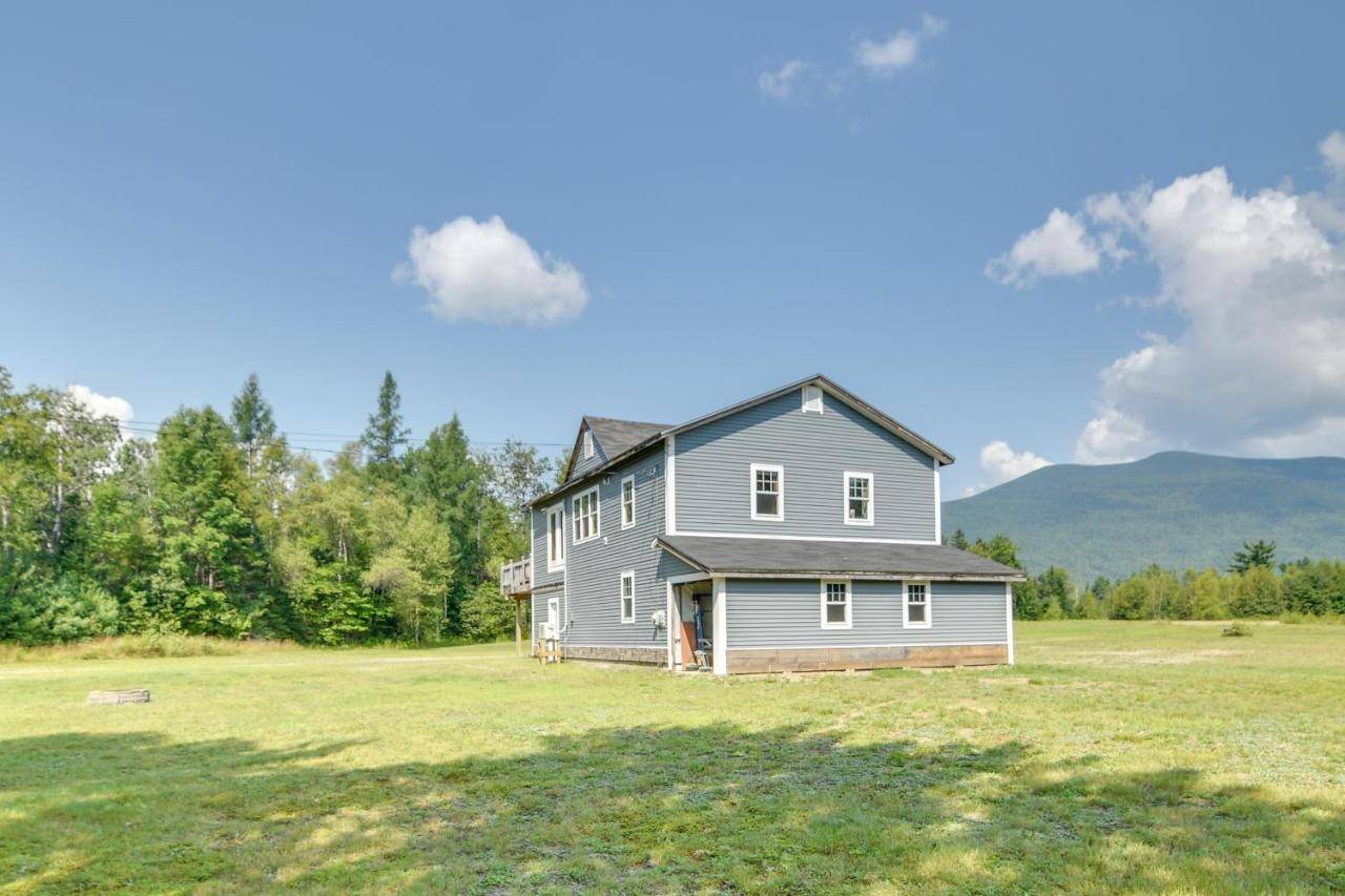 a gray house on a field with mountains in the background at Mountain-View Maine Cabin Ski, Hike and Bike! in New Portland