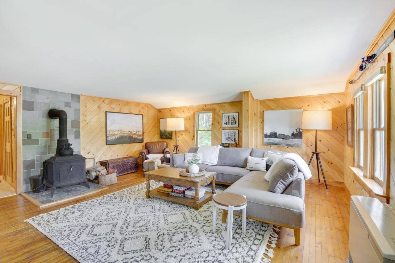 a living room with a couch and a fireplace at Gorgeous Sunday River Cabin with Saltwater Hot Tub! in Newry