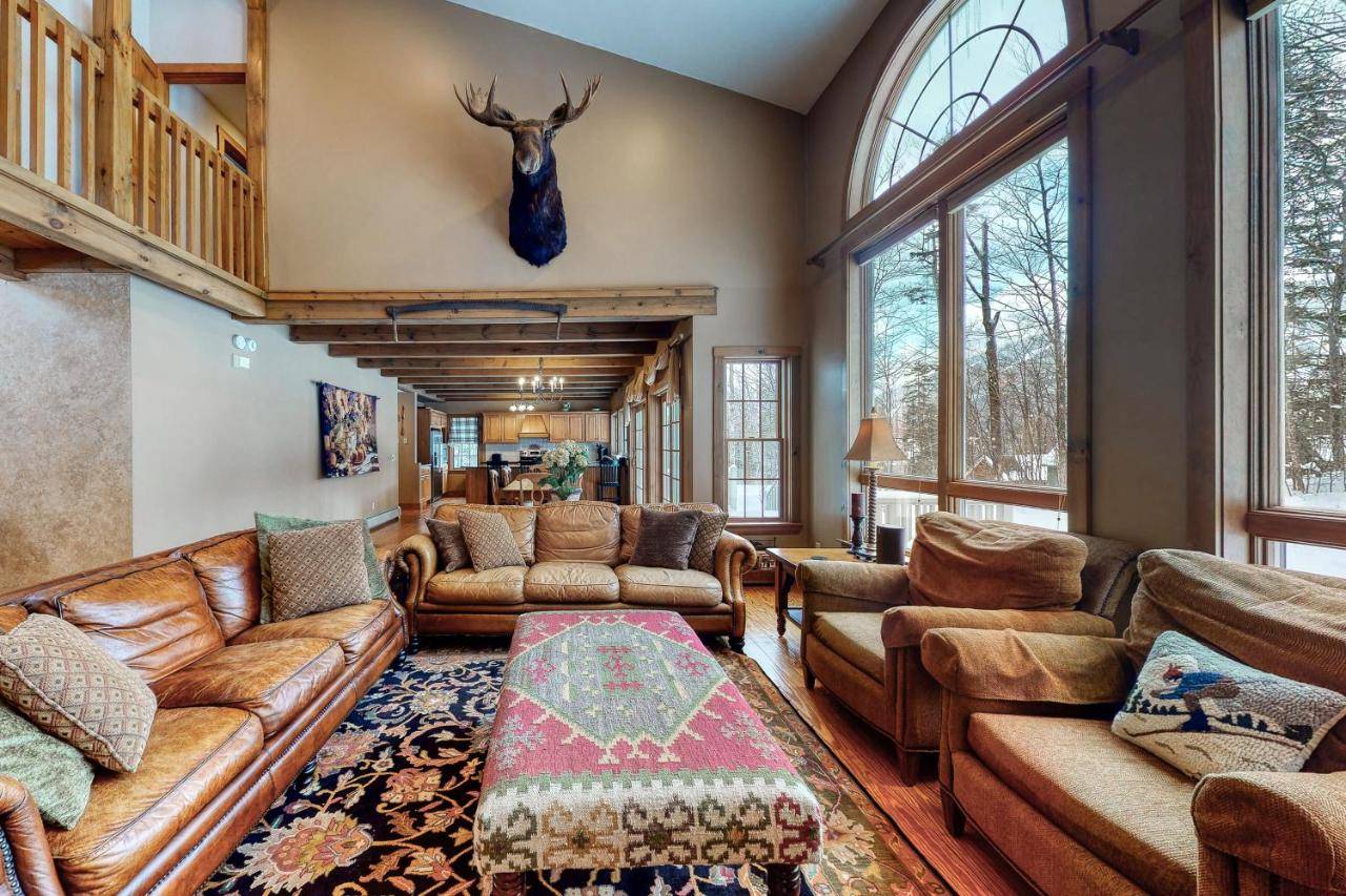 a living room with leather furniture and a deer head on the wall at Moose Lodge in Newry