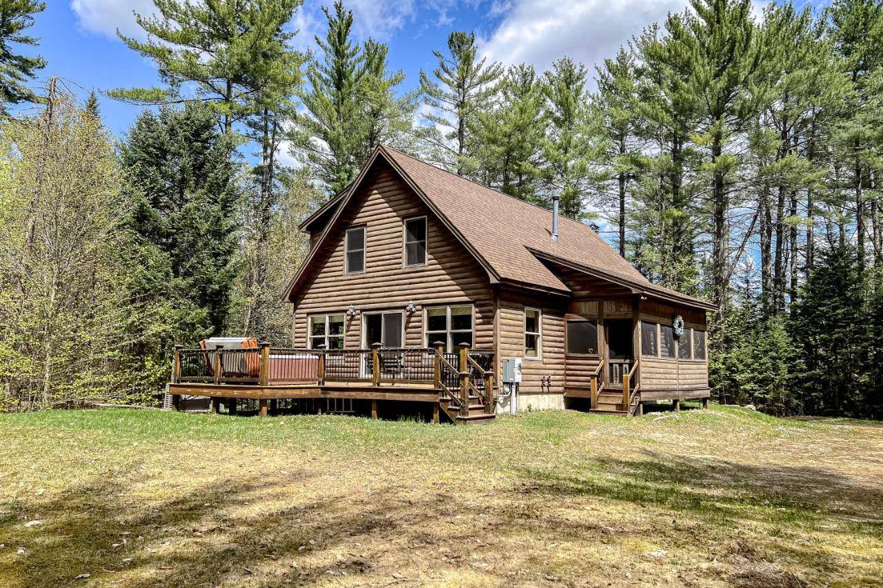 a large log cabin with a porch and a deck at Pinecone Lodge in Newry