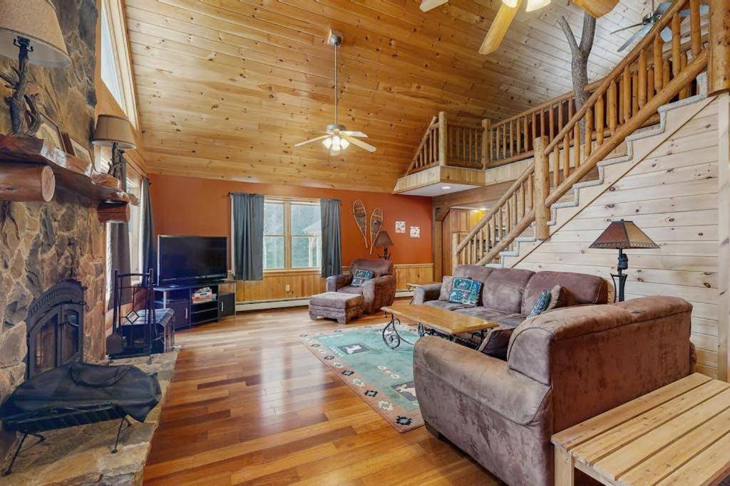 a living room with a couch and a fireplace at Snowy Pines Lodge in Newry