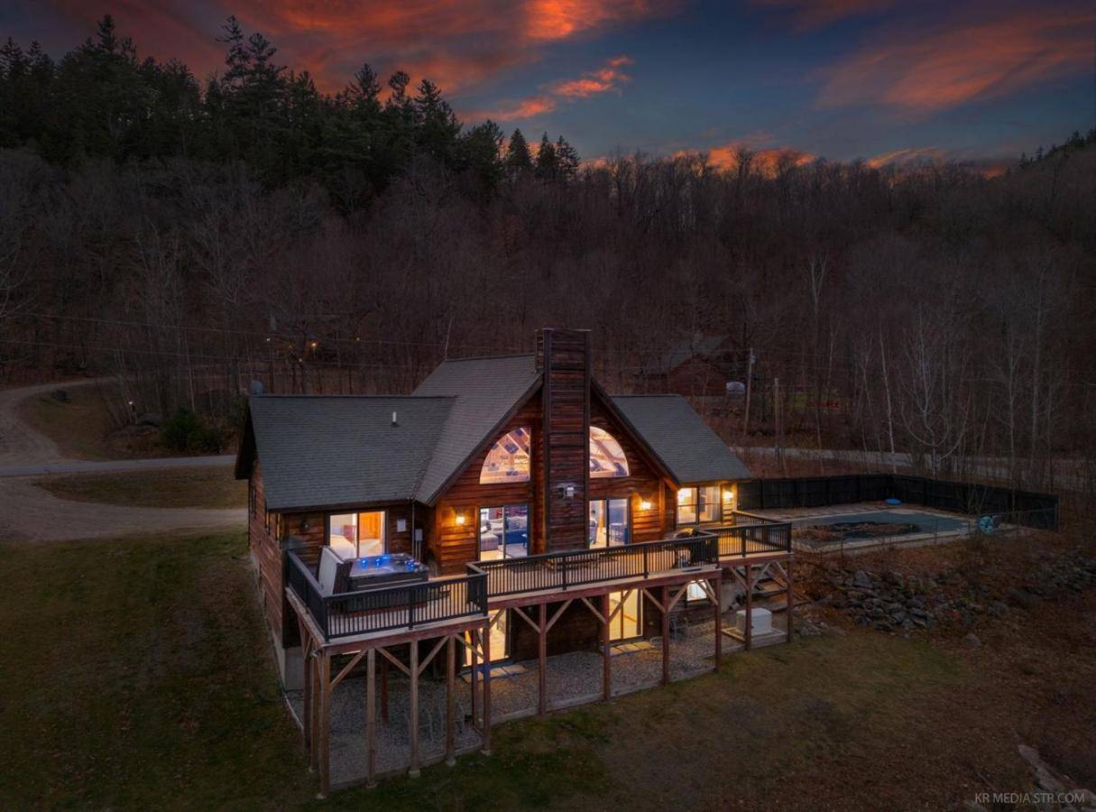 an overhead view of a large log home with a lit up roof at Spacious Retreat, Hot Tub, Arcade, Outdoor Pool! in Newry