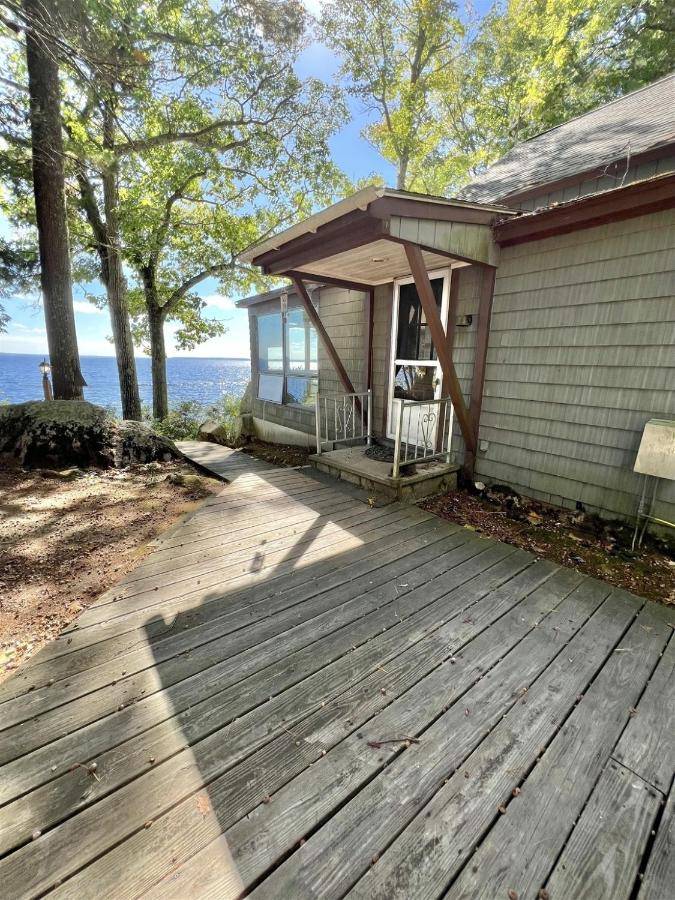 a porch of a house with a wooden deck at DOCKSIDE RETREAT LIMIT 14 home in North Sebago