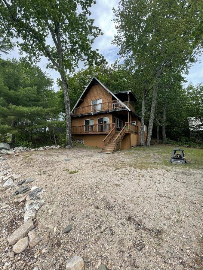 a large wooden house with a large yard at LITTLE SANDY-LIMIT 8 cottage in North Sebago
