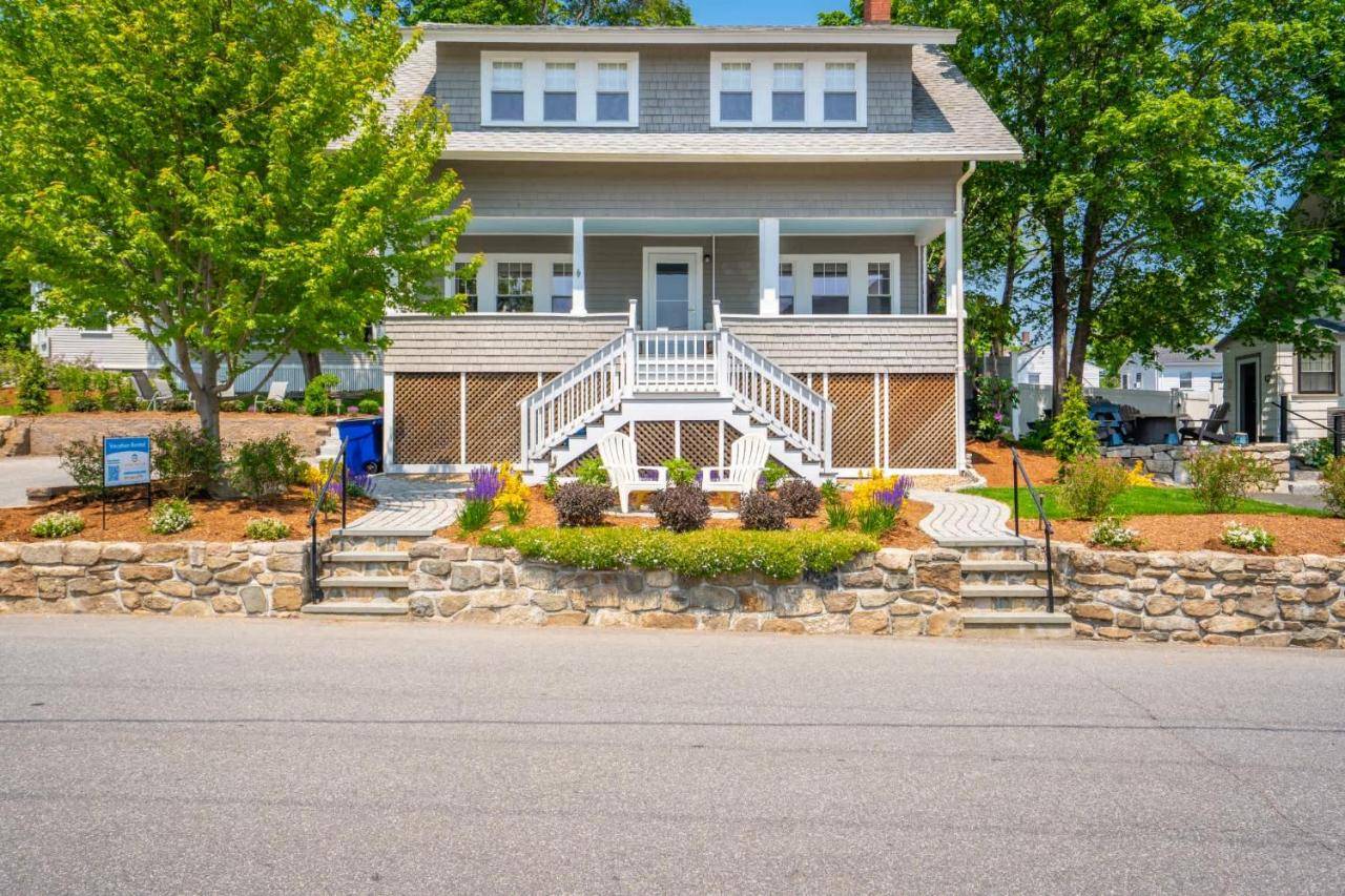 a house with a stone retaining wall and a porch at Downtown Ogunquit - Walk to Beach Shops & Seafood in Ogunquit