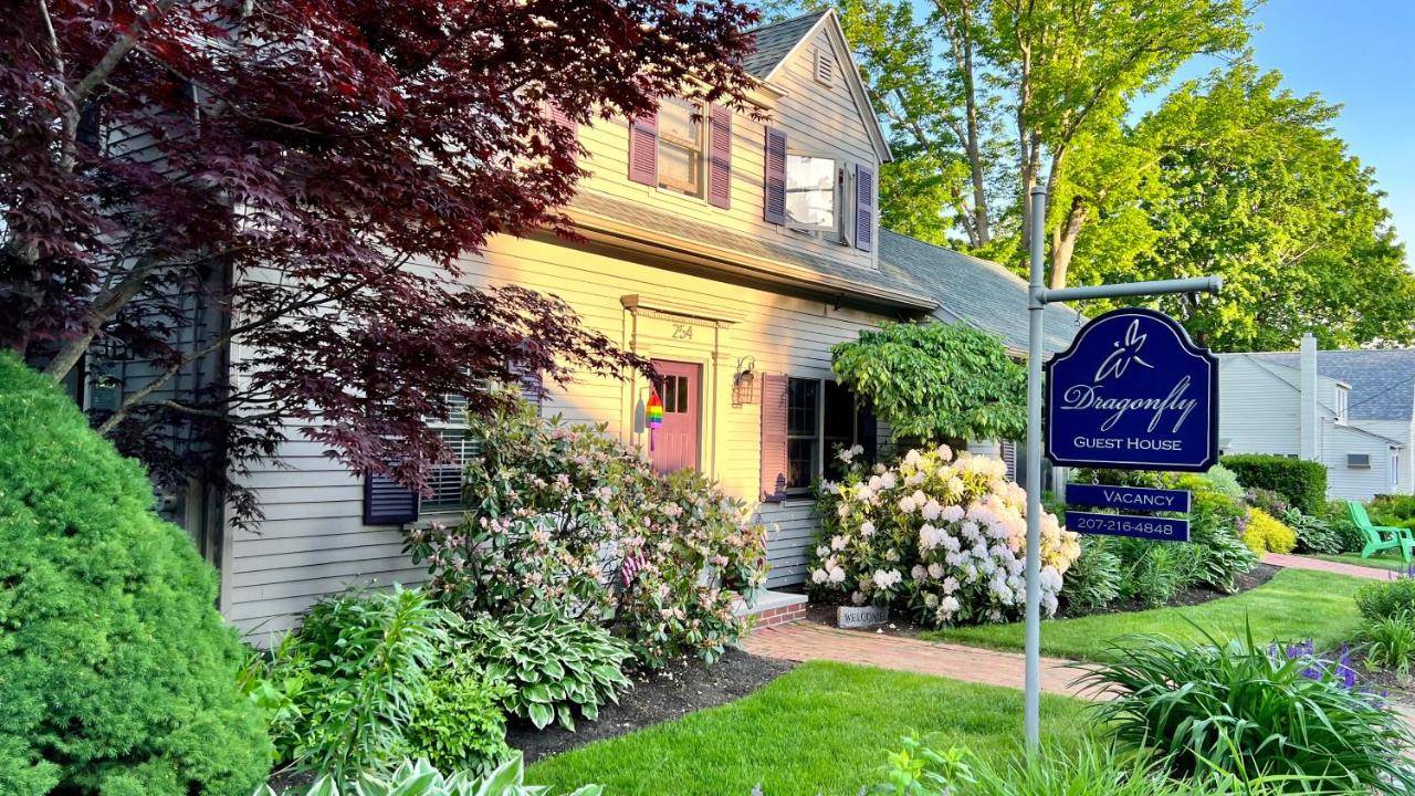 a yellow house with a sign in front of it at Dragonfly Guest House in Ogunquit
