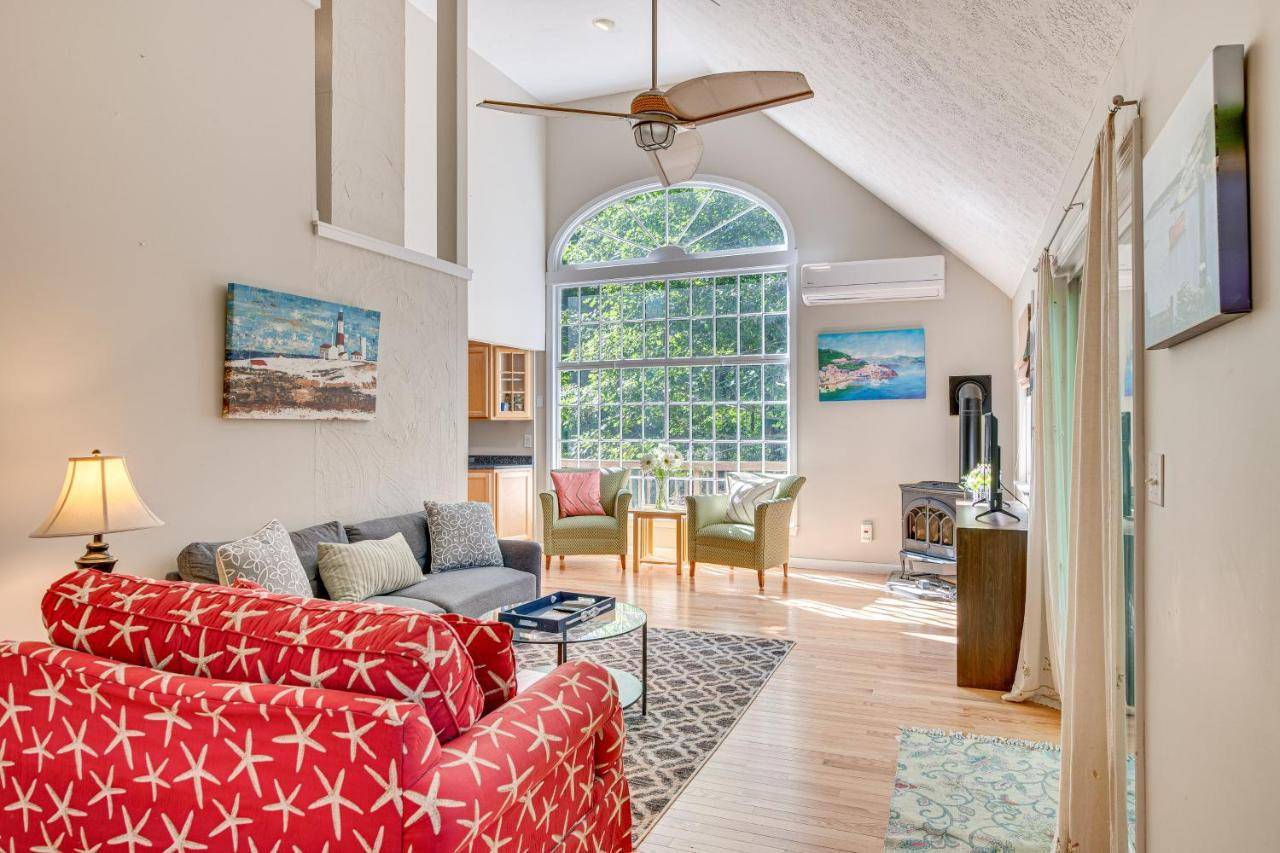 a living room with red furniture and a large window at half Mi to Ogunquit Beach Maine Home with Deck! in Ogunquit