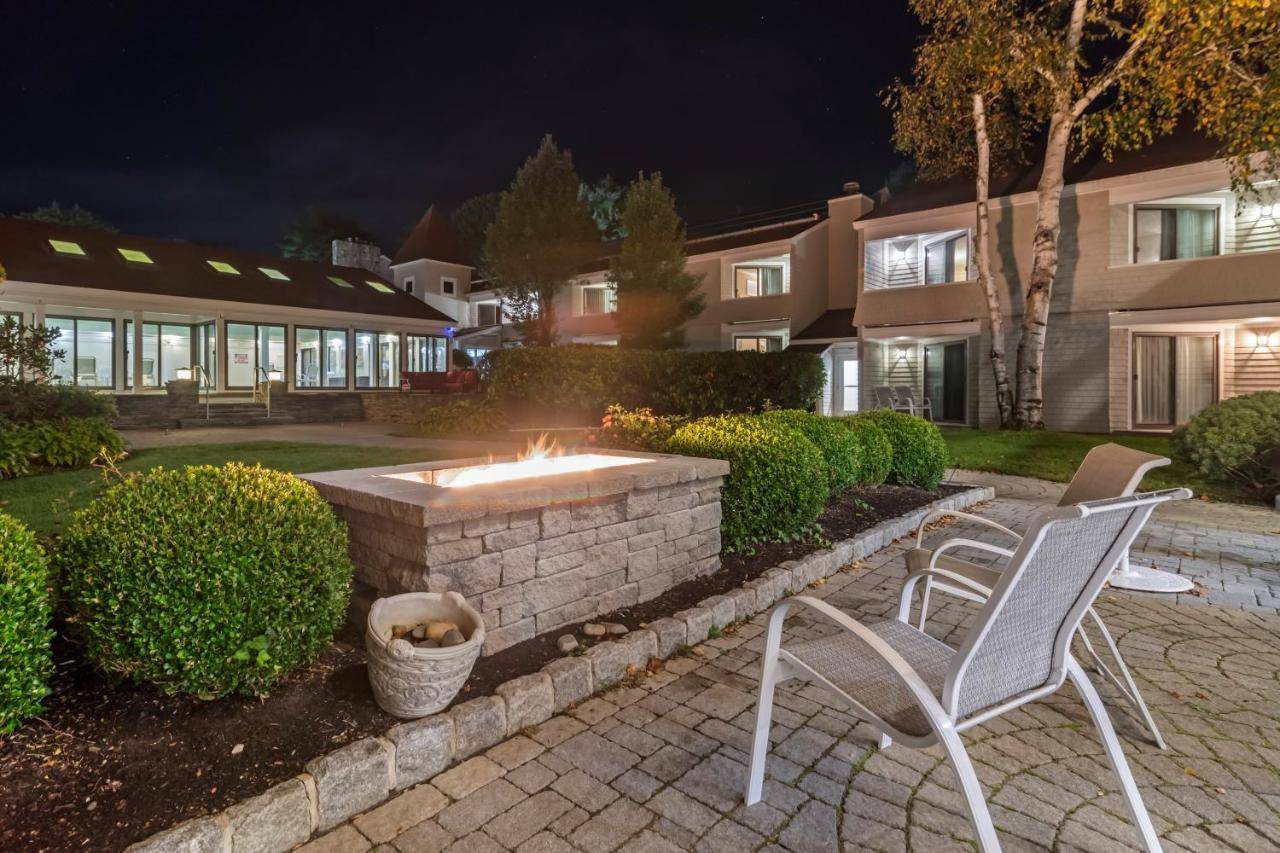 two chairs and a fire pit in a yard at night at Meadowmere Resort in Ogunquit