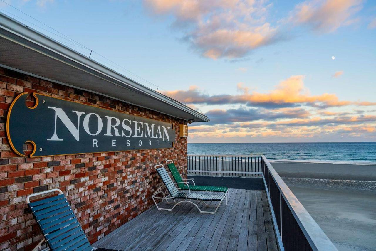 a sign on the side of anorwegian resort with two chairs on a balcony at Norseman Resort on the Beach in Ogunquit