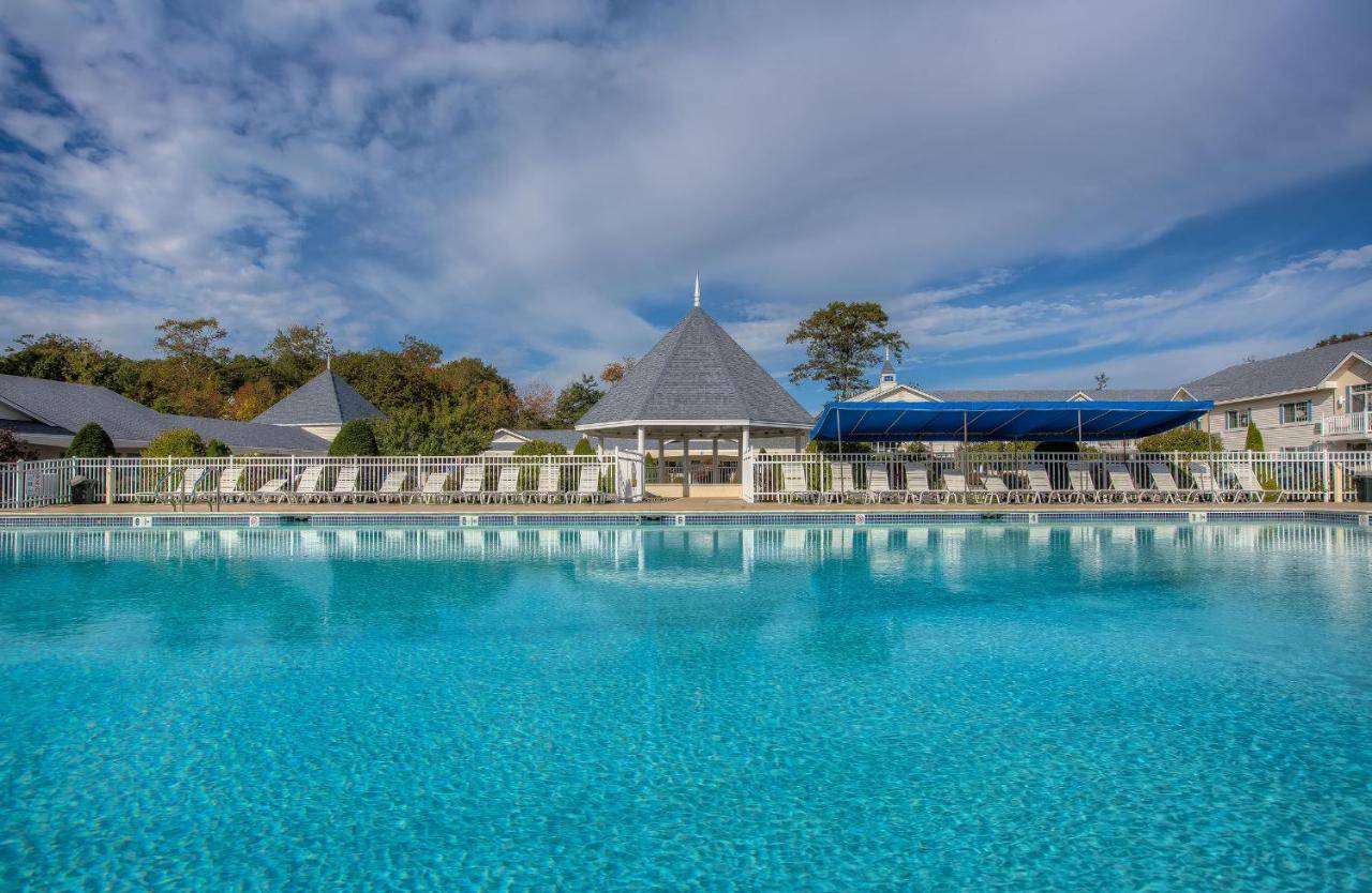a large pool of blue water in front of a house at Ogunquit Hotel and Suites in Ogunquit