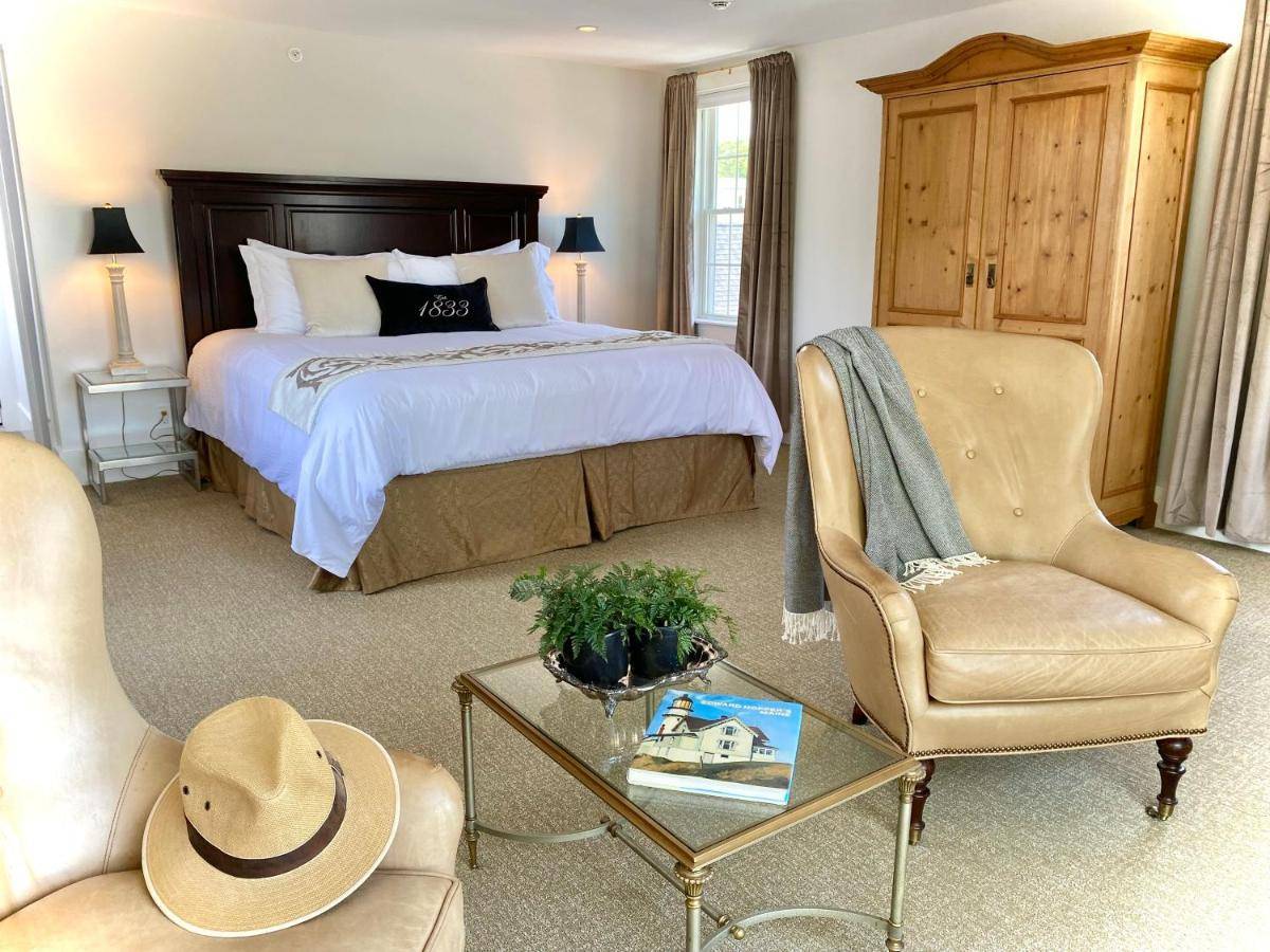 a bedroom with a bed and a table and chairs at Old Village Inn Ogunquit in Ogunquit