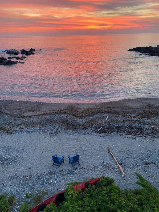 two blue chairs sitting on a beach near the water at Tide's Edge Oceanfront Condo in Ogunquit