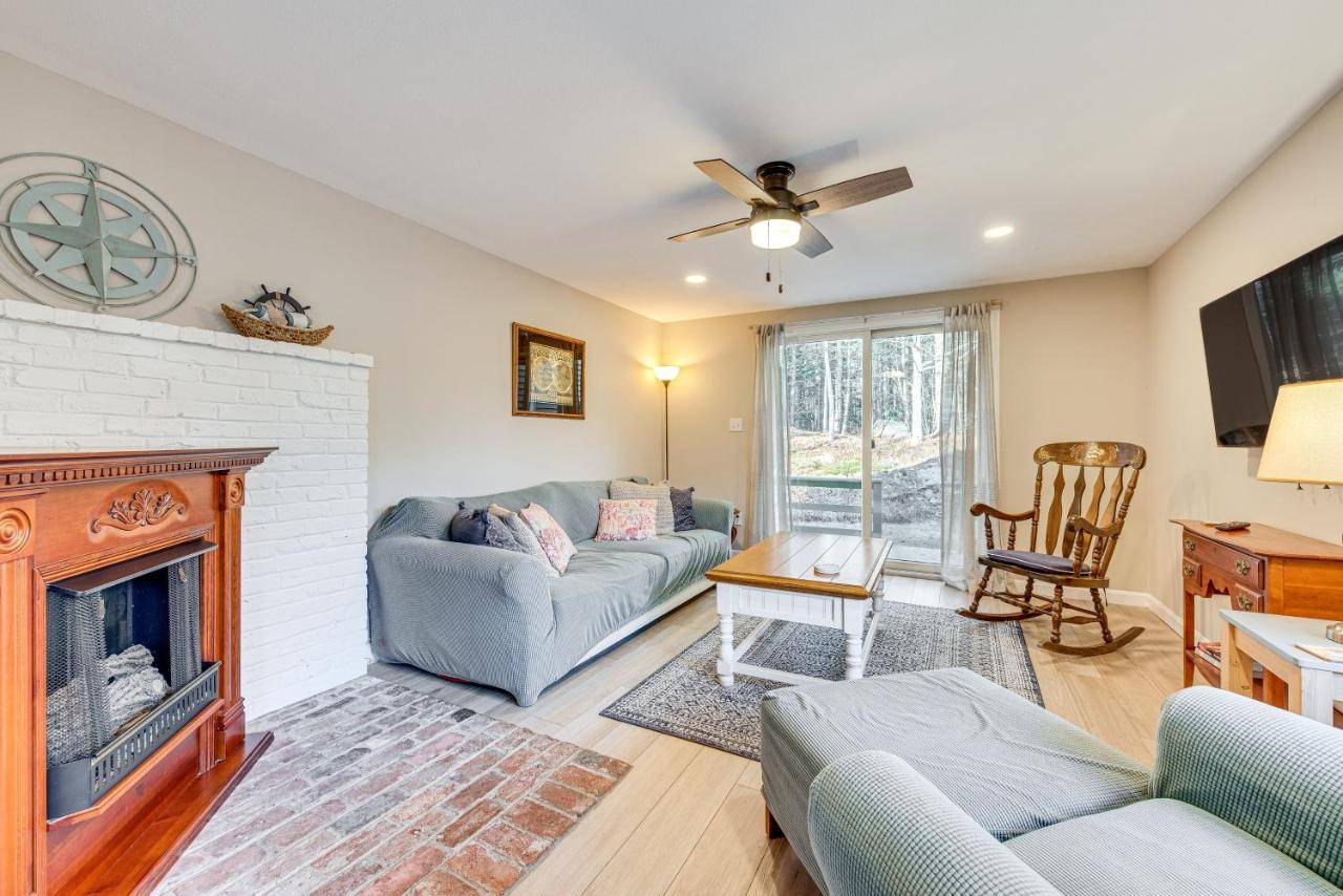 a living room with a couch and a fireplace at Tranquil Ogunquit Condo Walk to Beach and Marina! in Ogunquit