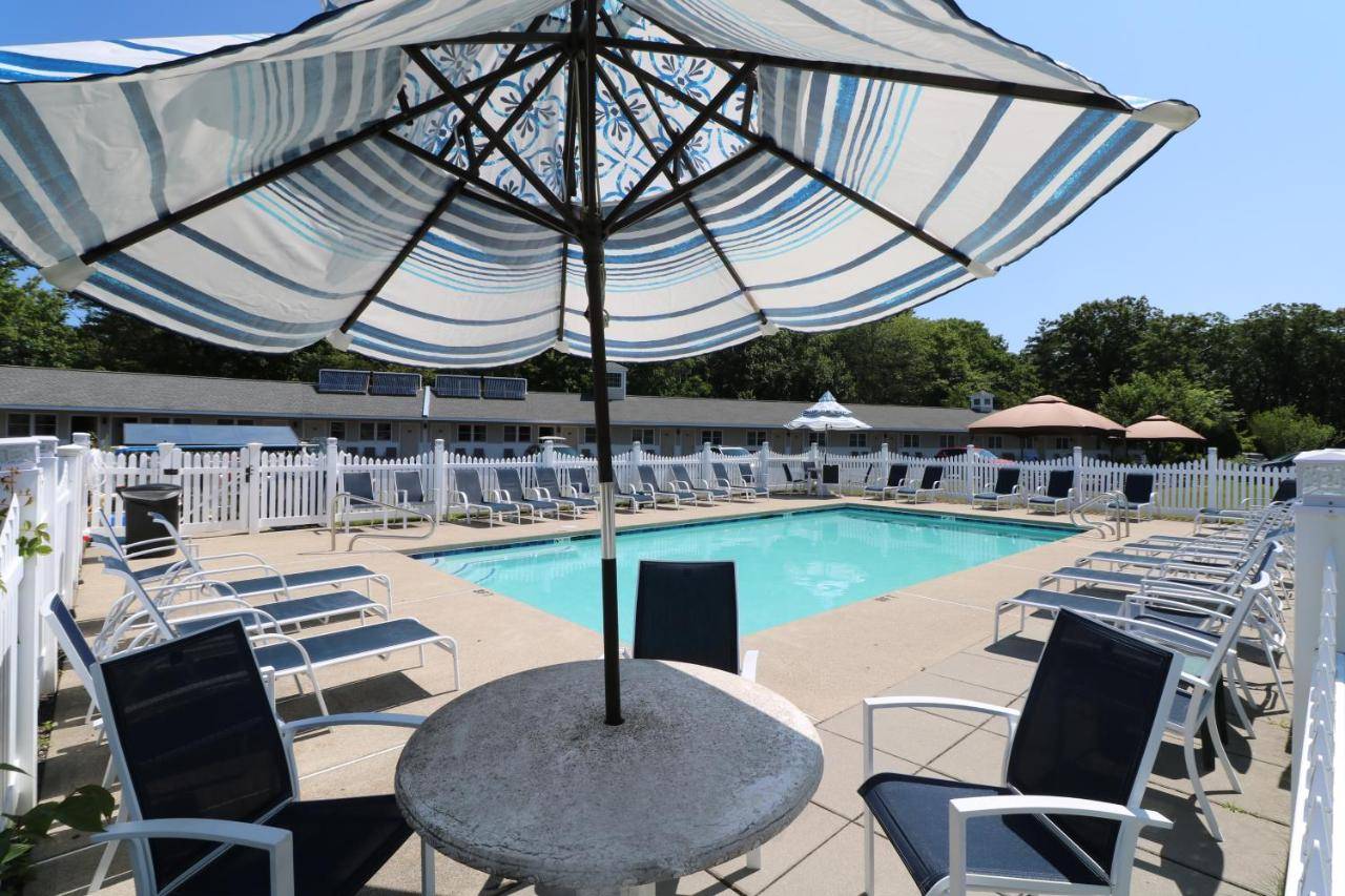 a table with an umbrella in front of a pool at Wells-Ogunquit Resort Motel & Cottages in Ogunquit
