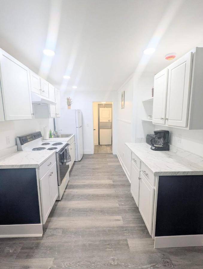 a white kitchen with white counters and white cabinets at 3BD, 7 min to Beach, pet friendly, 3 FREE parking! in Old Orchard Beach