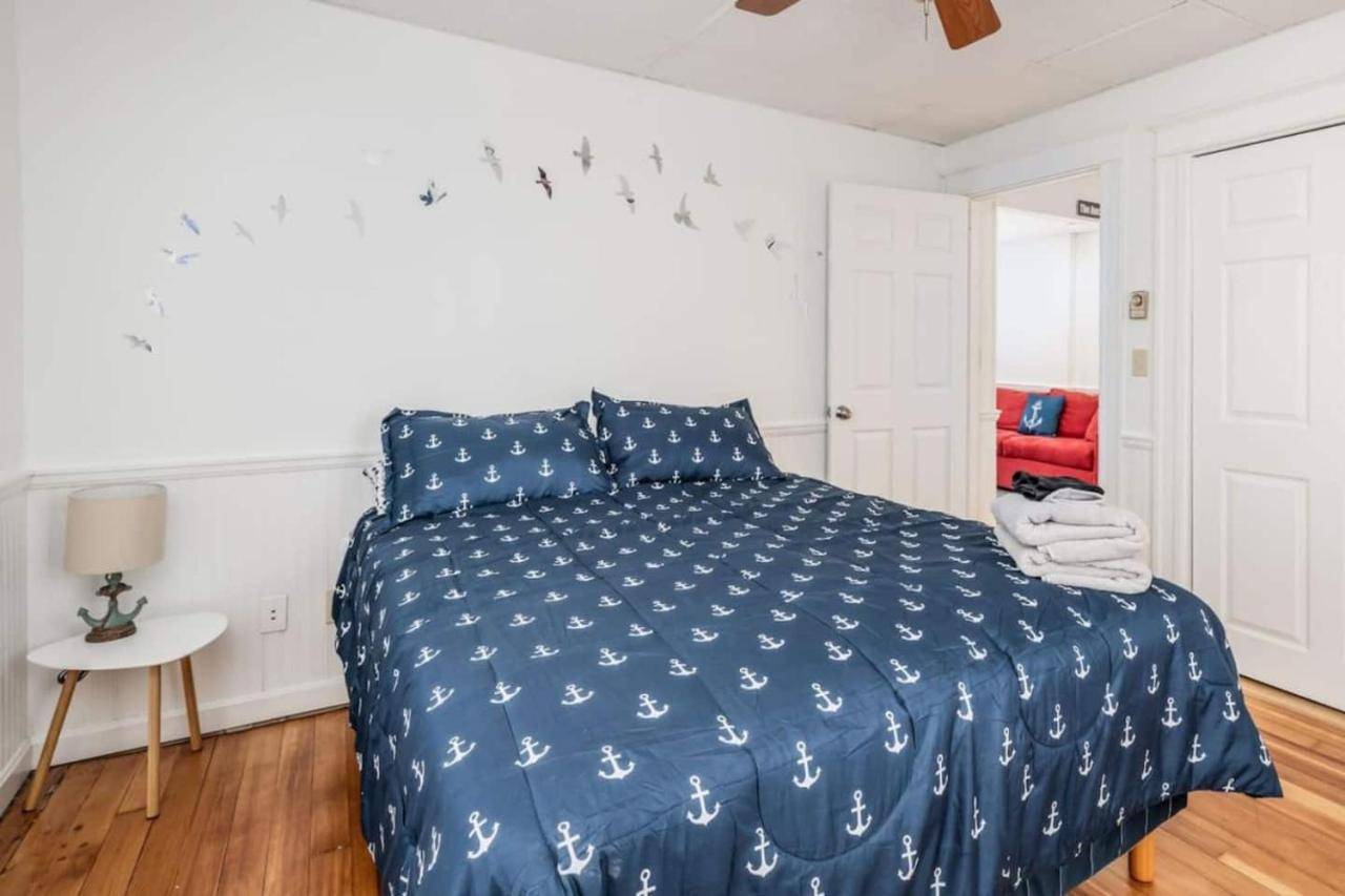 a bedroom with a bed with a blue comforter at Anchors Away Cottage 5BR 10-Min Walk to Beach in Old Orchard Beach