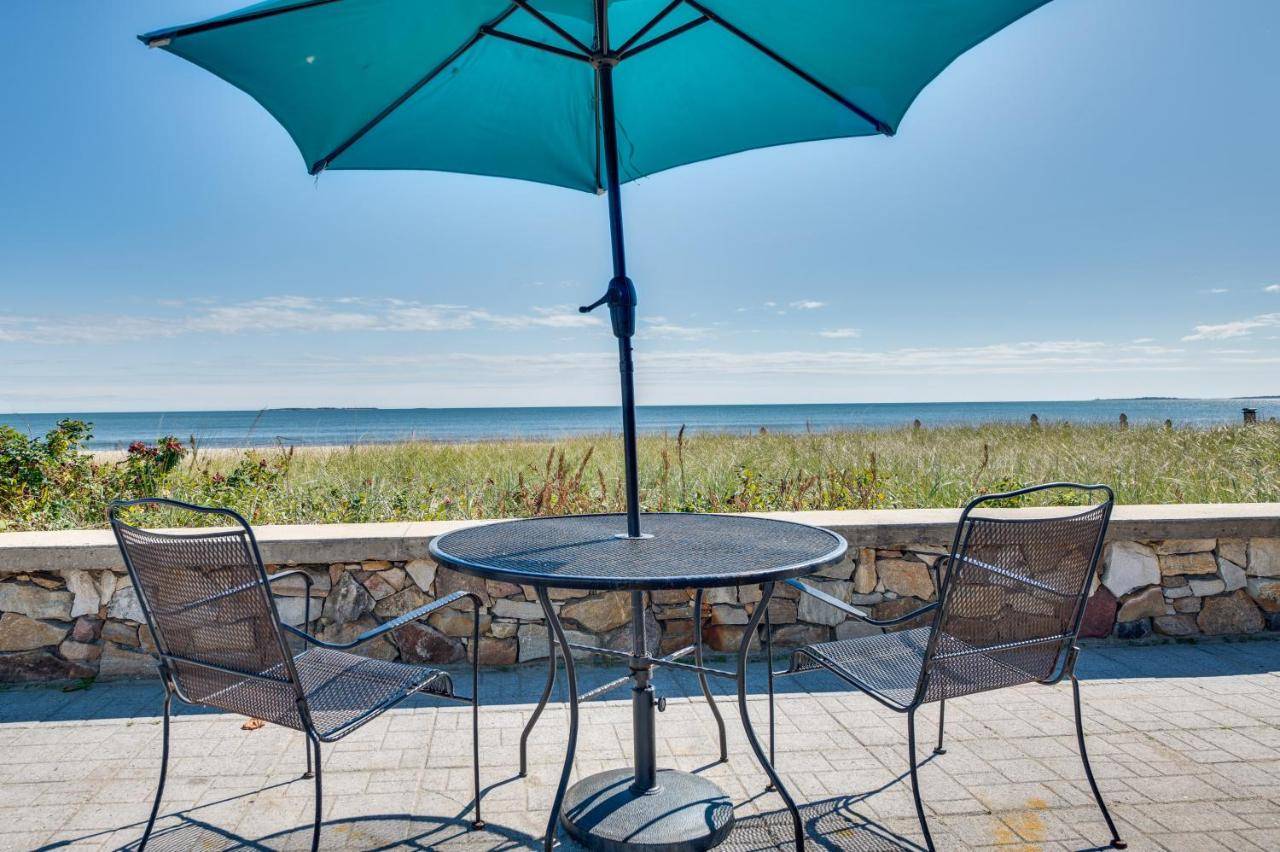 a table and chairs with an umbrella and the ocean at Beachfront 14 Condo on Old Orchard Beach in Old Orchard Beach