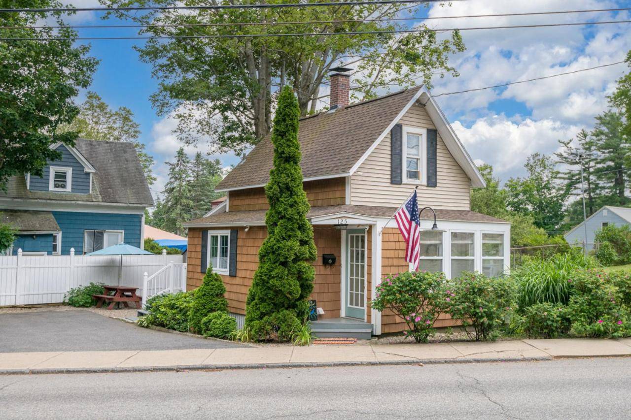 a house with an american flag in front of it at Charming Centrally Located Seaside Retreat in Old Orchard Beach