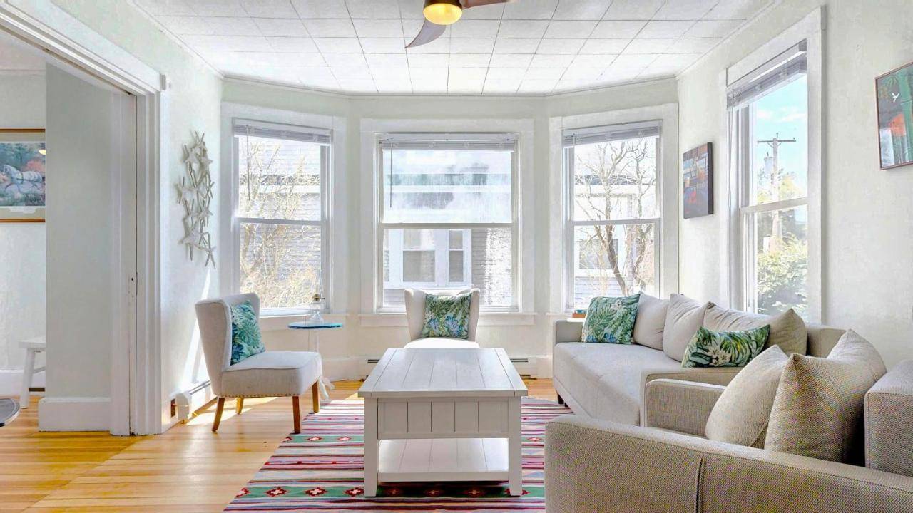 a living room with a couch and some windows at Dancing Queen by Bayley Vacation Rentals in Old Orchard Beach