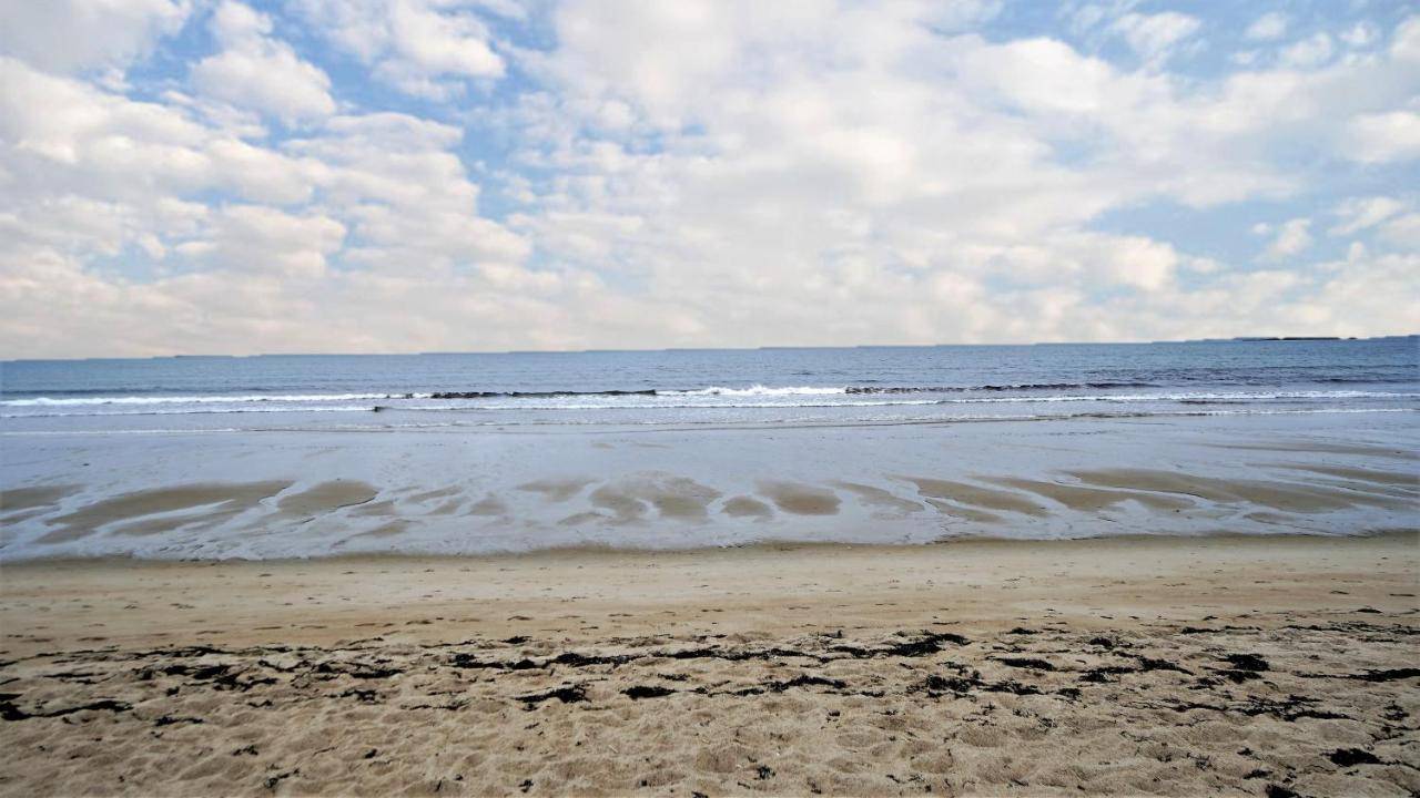 a sandy beach with waves in the ocean at Maine-ly Waves by Bayley Vacation Rentals in Old Orchard Beach