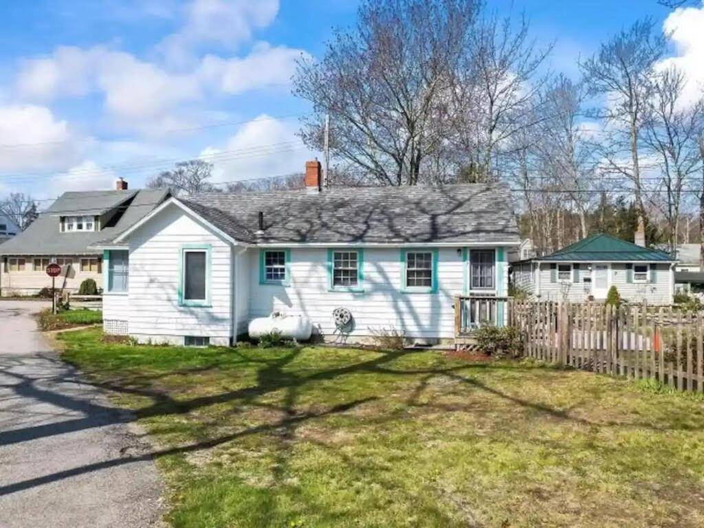 a white house with a fence at Make Lasting Memories at the Bougie Beach Bungalow in Old Orchard Beach
