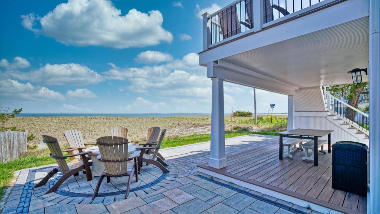 a patio with a table and chairs and the beach at Nautical Point by Bayley Vacation Rentals in Old Orchard Beach
