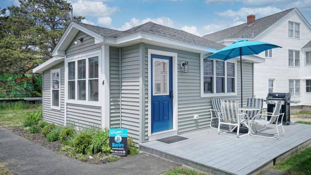 a house with a blue door and a table and an umbrella at Nautical View by Bayley Vacation Rentals in Old Orchard Beach