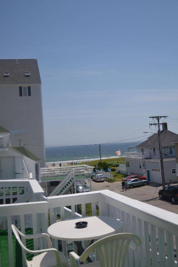 a balcony with a table and chairs and the ocean at The Oceanic Inn in Old Orchard Beach