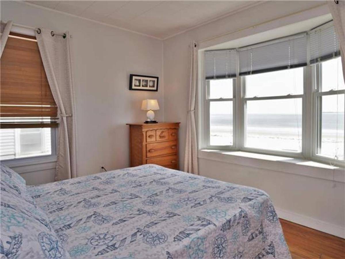 a bedroom with a bed and two windows and a dresser at Sandy Beach at Port by Bayley Vacation Rentals in Old Orchard Beach