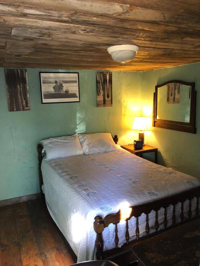 a bedroom with a large bed with a wooden ceiling at Seafarer Inn and Cottages in Old Orchard Beach