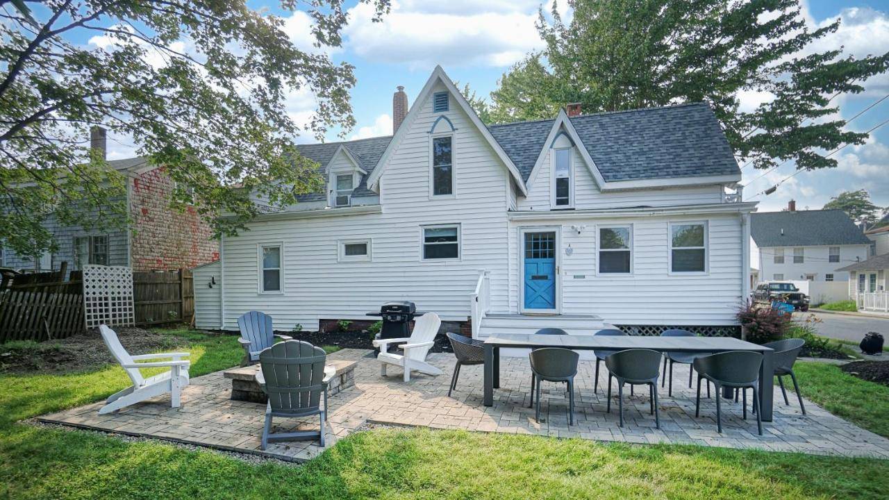 a patio with a table and chairs in front of a house at Summer by the Sea by Bayley Vacation Rentals in Old Orchard Beach