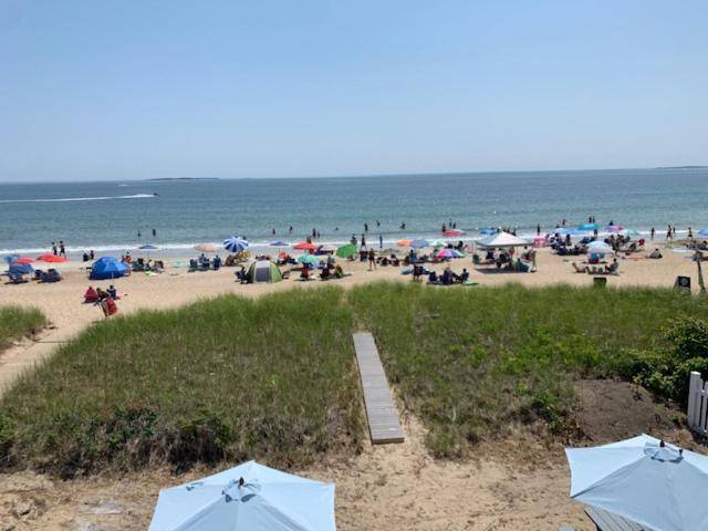 a beach with many umbrellas and a crowd of people at The York in Old Orchard Beach