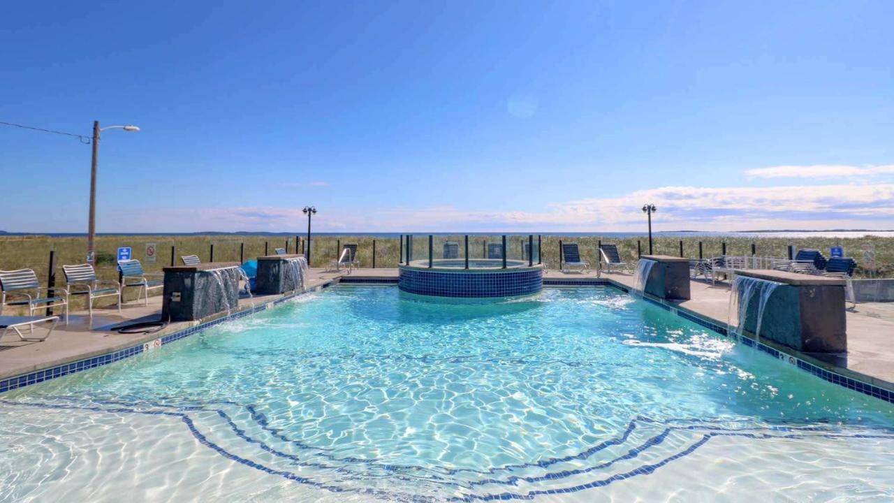 a swimming pool at a resort with chairs and water at Waves Oceanfront Resort in Old Orchard Beach
