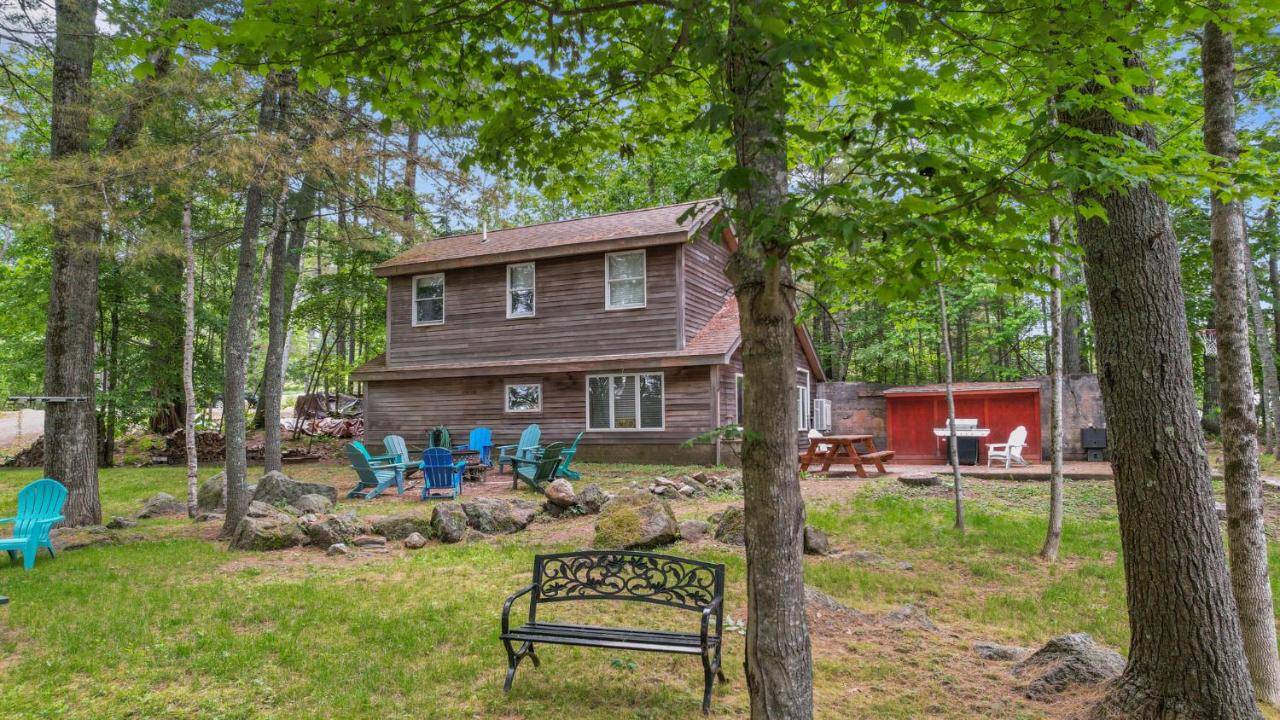 a house with chairs and a bench in front of it at Waterfront-40min to Acadia-Main House-Kayaks in Orland