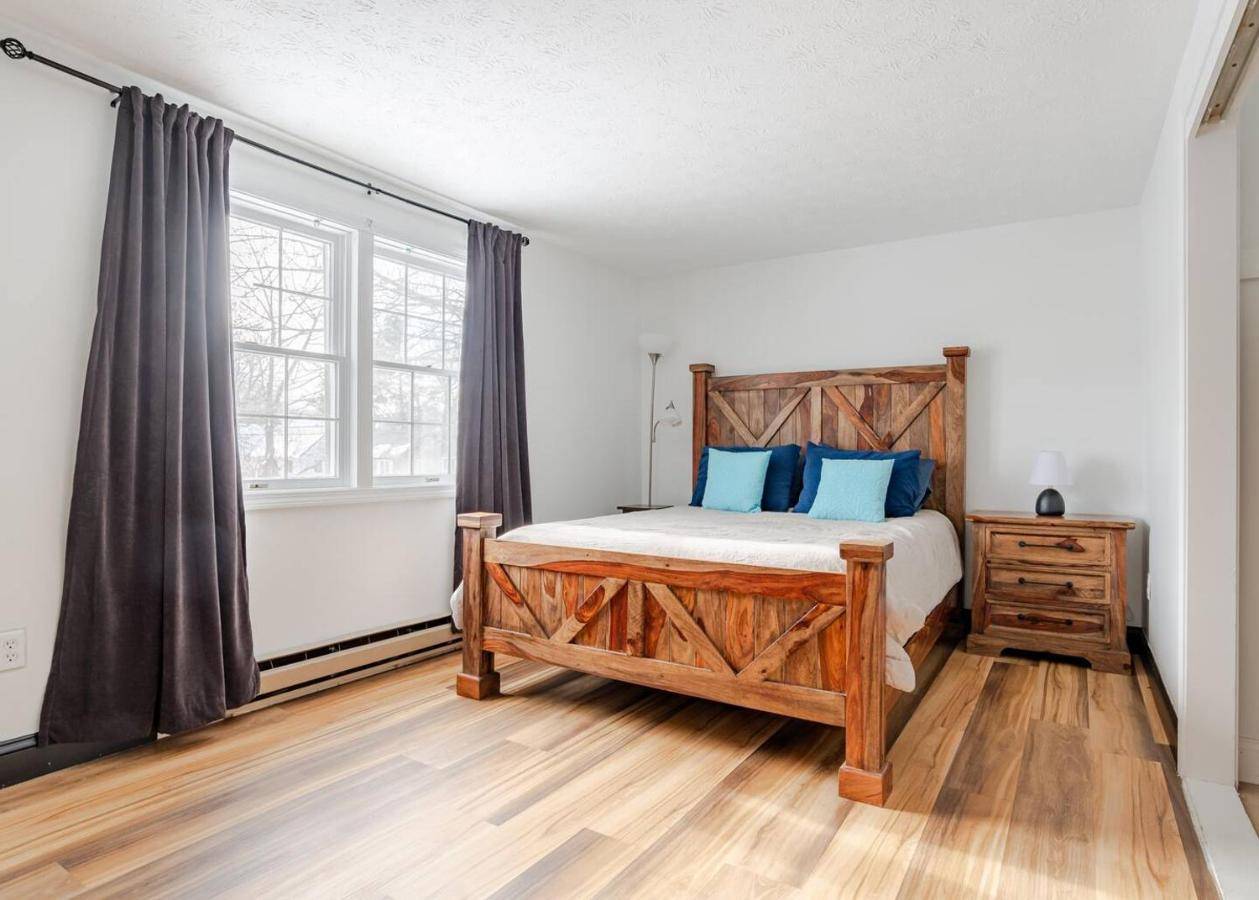 a bedroom with a bed with blue pillows and a window at 2BR WParking Full Kitchen 5 Min to Old Port in Portland