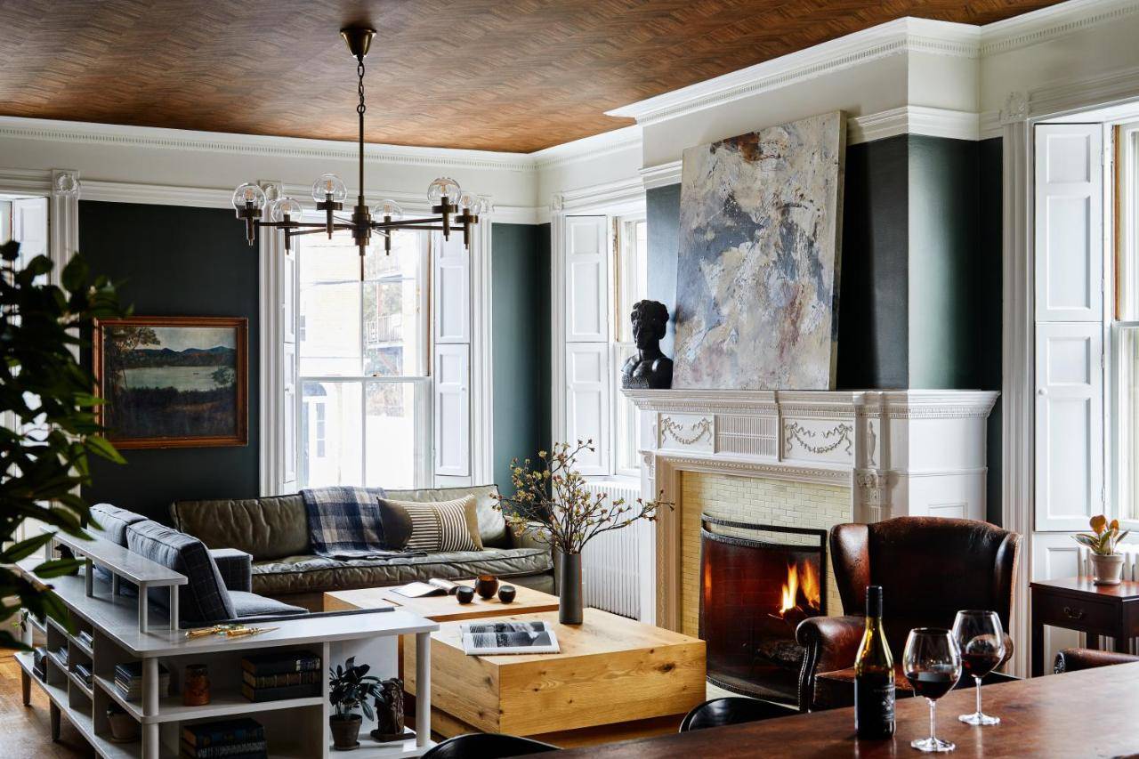 a living room with a couch and a fireplace at Blind Tiger Portland - Danforth Street Guest House in Portland