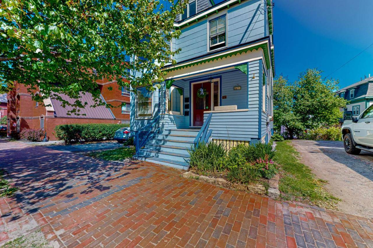 a blue house with a red door on a brick driveway at Cumberland Casa - B in Portland