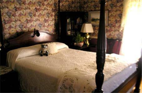 a bedroom with a bed with a teddy bear on it at Fleetwood House Bed and Breakfast in Portland