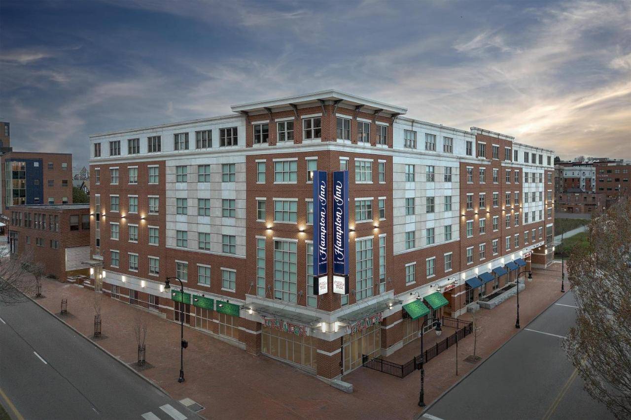 a large brick building with a blue sign on it at Hampton Inn Portland Downtown Waterfront in Portland