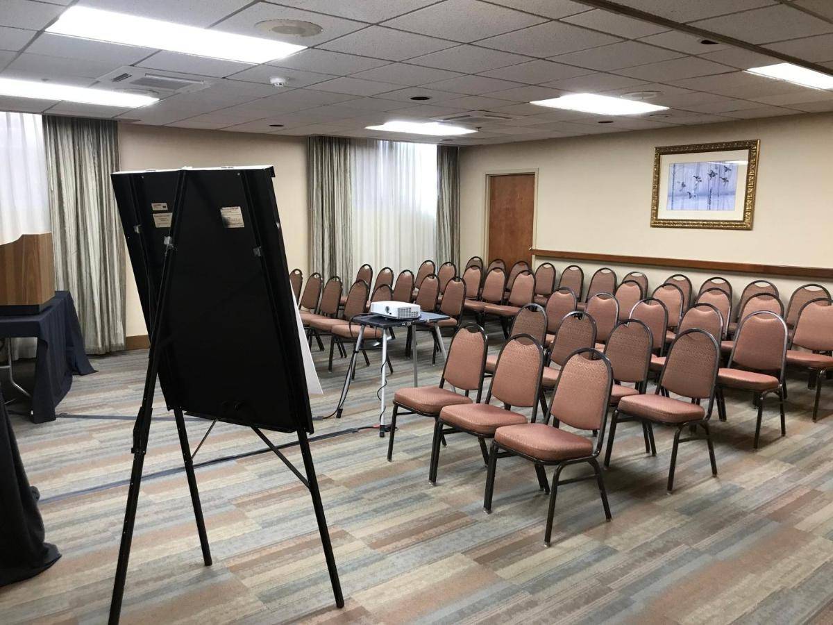 an empty room with chairs and a projection screen at Holiday Inn Portland-By the Bay by IHG in Portland